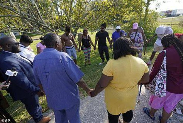Panicked locals were seen forming a prayer circle with political leaders in the middle of the street following the tragic shooting